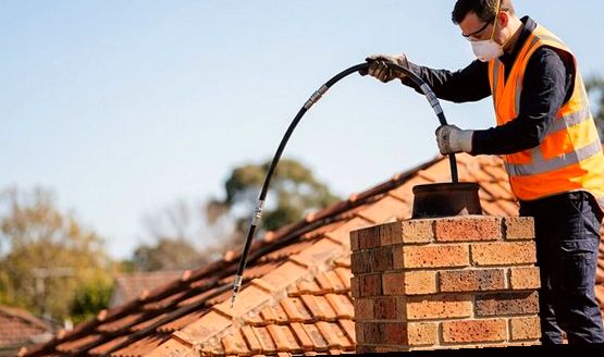 Two techs checking a flue with rods and a scope
